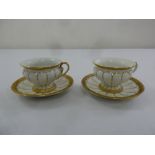 Meissen a pair of cream and gilded cups and saucers, marks to the base