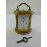 Matthew Norman an oval brass repeating carriage clock with hinged carrying handle and key
