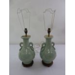 A pair of celadon Oriental style table lamps with ring handles on raised wooden bases