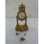 A 19th century French gilded metal mantle clock of architectural form, enamel dial with Roman