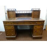 An oak Dickens desk with tooled leather top, drawers with turned wooden handles on original