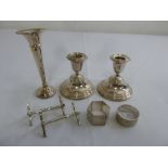 A pair of filled silver candlesticks, a silver vase, two silver plated knife rests and two napkin