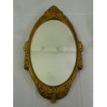 A shaped oval gilded wooden wall mirror