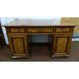 A 19th century rectangular mahogany and walnut pedestal desk with three drawers and two cupboards