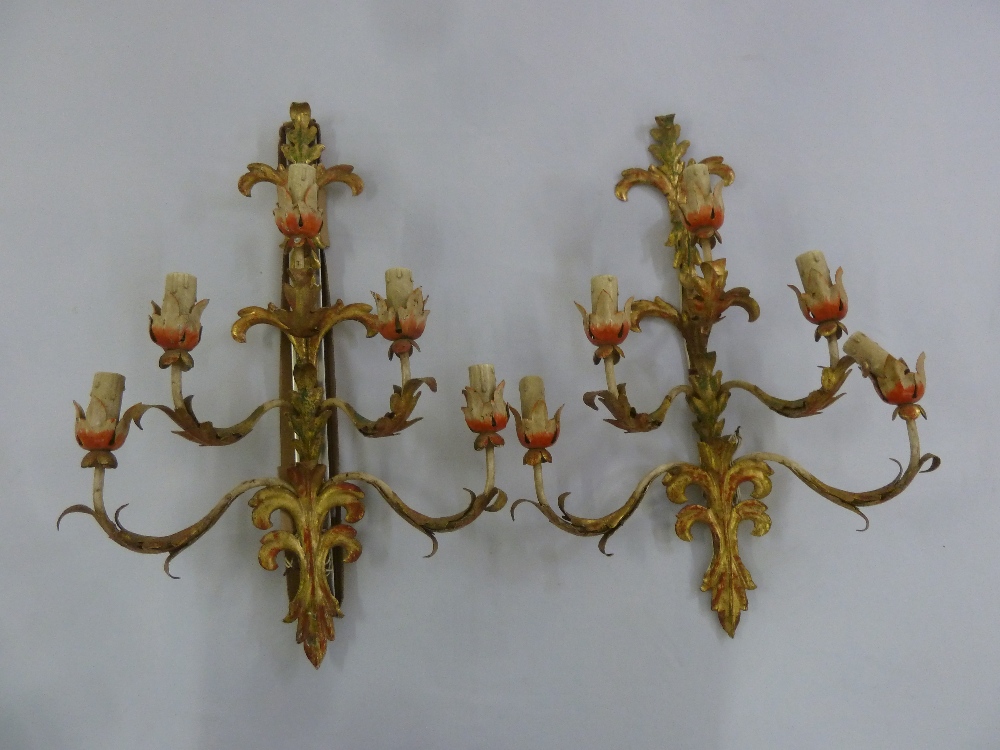 A pair of French rustic gilt metal five branch wall mounted candle holders