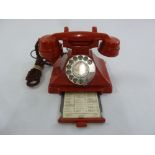 A 20th century red reproduction Bakelite telephone with sliding drawer and original handset cable