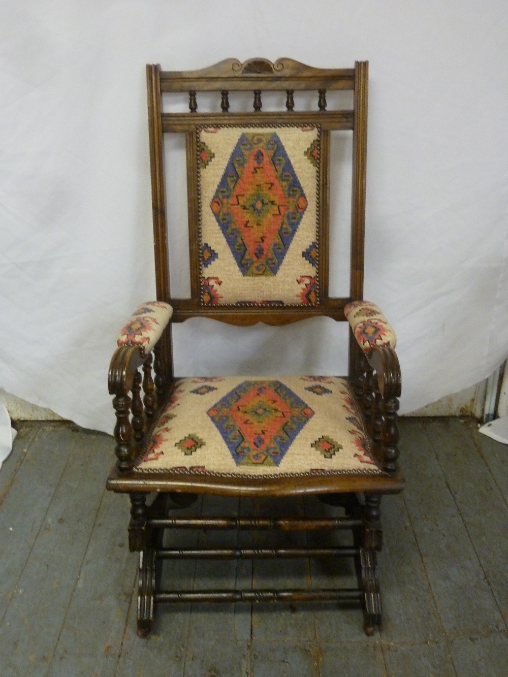 An early 20th century mahogany upholstered rocking chair