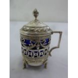 Russian white metal mustard pot, scroll pierced sides, the hinged embossed cover with bud finial all