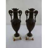 A pair of French 19th century spelter vases on raised marble circular bases with gilt metal paw