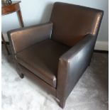 A brown leatherette armchair on four rectangular mahogany legs