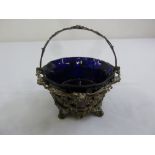 A Victorian silver circular basket with pierced vine leaf sides and swing handle on four scroll