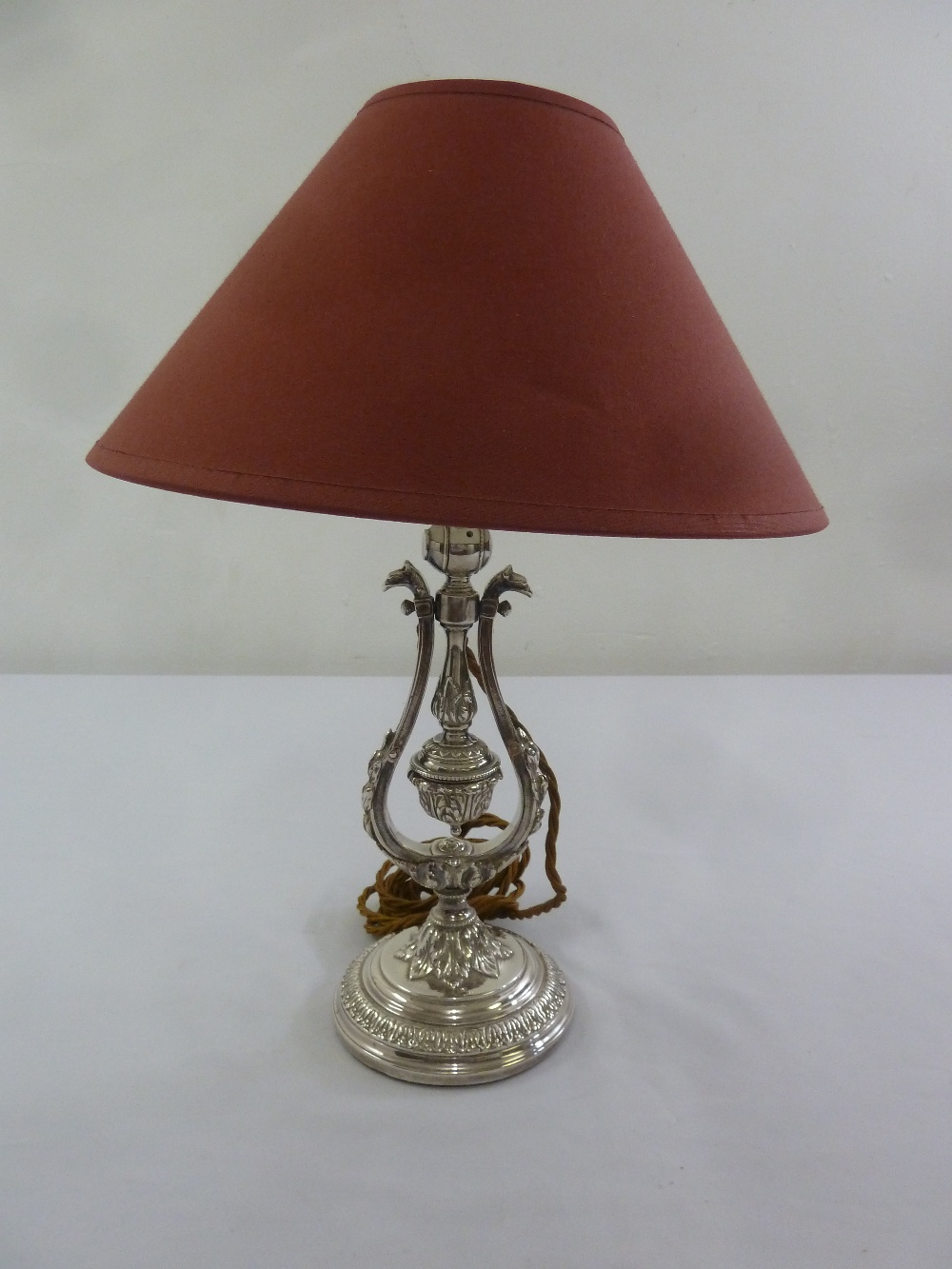A silver plated Victorian style table lamp on raised circular base to include shade