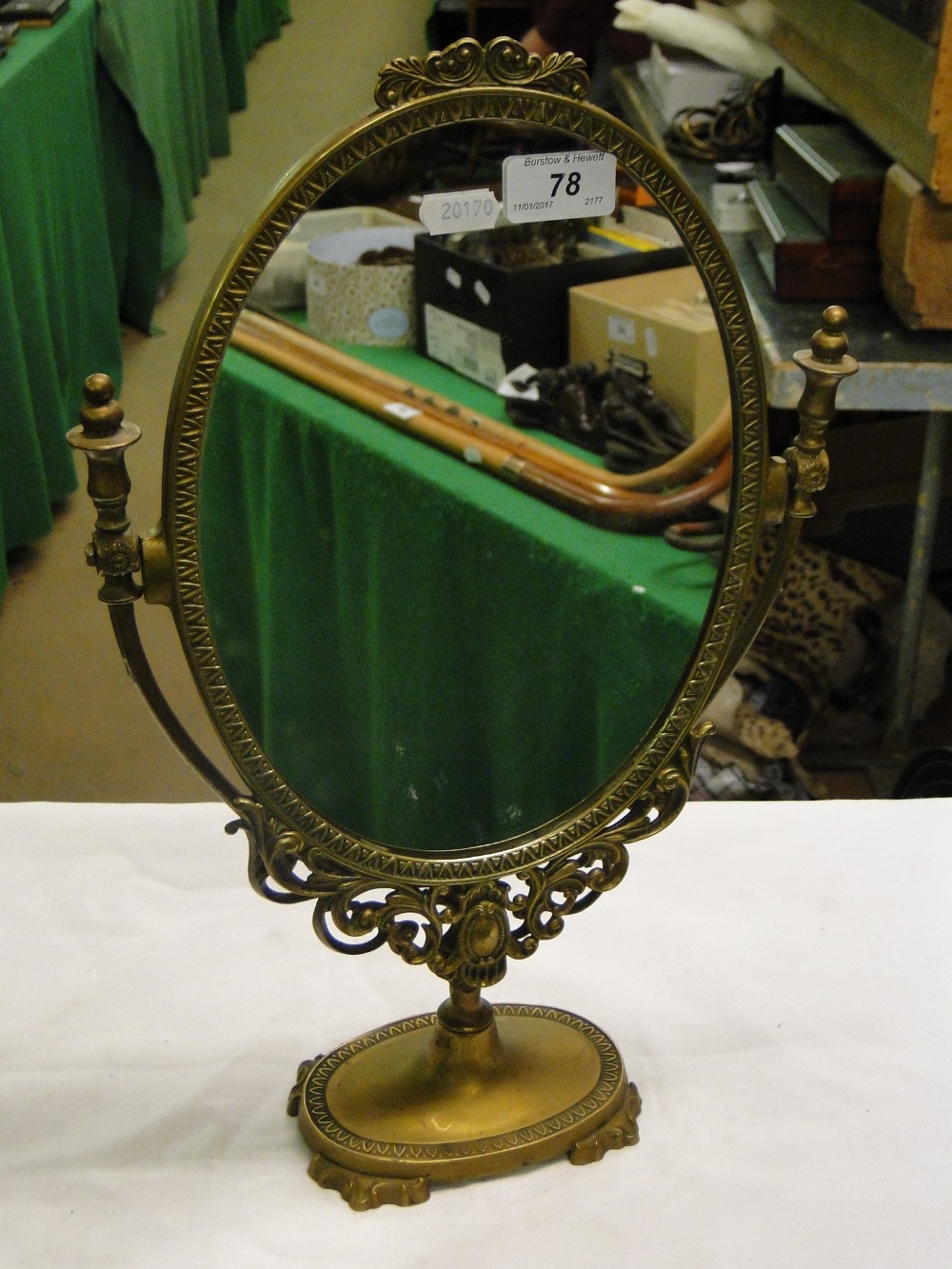 An oval brass swing toilet mirror