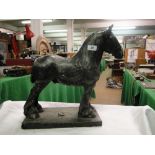 A metallic effect plaster figure of a heavy horse on plinth
