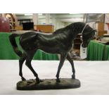 A verdigris bronze figure of a walking horse,