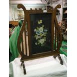 An Edwardian lyre shape inlaid mahogany firescreen, with painted panel of pansies, height 27.5".