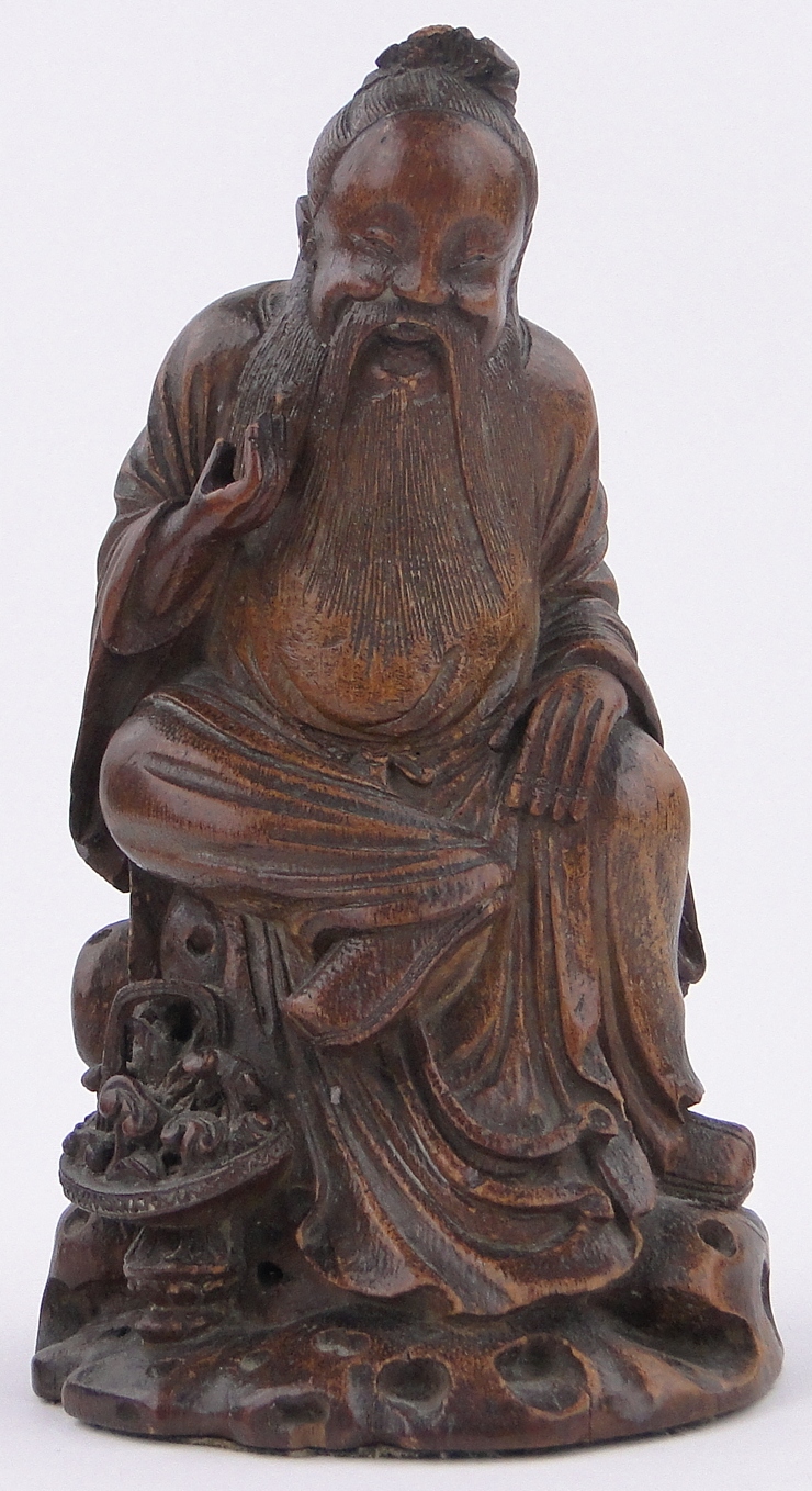A Chinese carved stained wood figure of a sage, height 9.5".