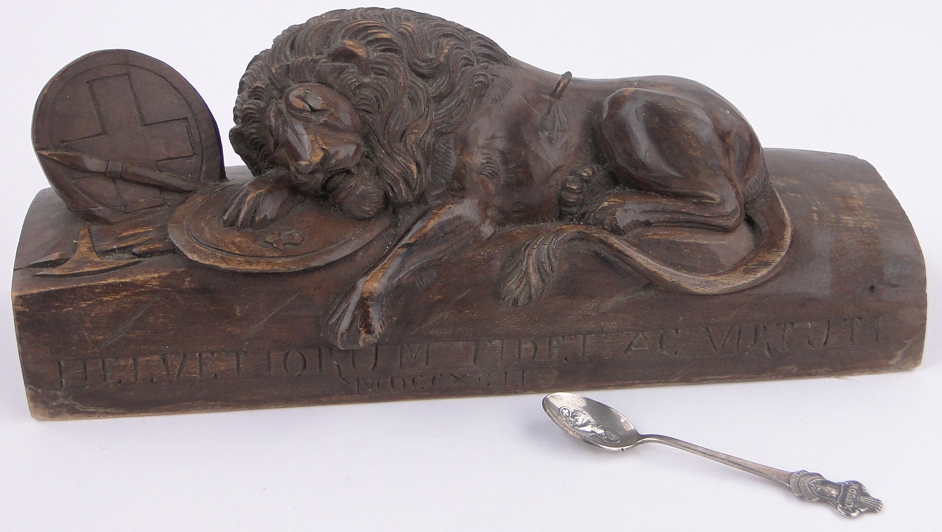 An Antique carved and stained wood heraldic lion, inscribed on base with date 1792, length 11.5".
