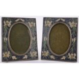 A pair of brass and enamelled photo frames, with floral surrounds, 7" x 5.5".