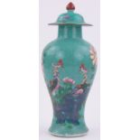 A Chinese turquoise glazed porcelain vase and cover, with enamel bird and blossom design, height 11.