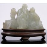 A Chinese carved white jade group of 3 figures, carved hardwood stand, length 3".