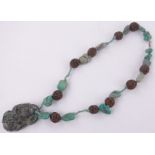 A Chinese relief carved nut and turquoise necklace with carved fruit design turquoise pendant