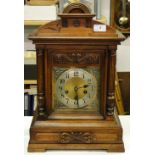 A Victorian carved wood cased bracket clock.