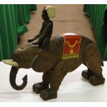 A carved wood elephant with jointed limbs and mahout.