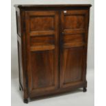 An Antique continental walnut cupboard, having 2 panelled doors raised on shaped feet, width 3'10",