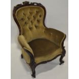 A Victorian button upholstered armchair, with carved showwood surround.