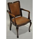 An early 20th century stained beech framed upholstered reclining elbow chair,