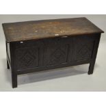 An Antique carved oak coffer, with plank top and carved panelled front, raised on stile feet,