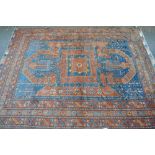 A large red ground Caucasian rug with symmetrical pattern, and 5 borders, 12' x 9'8".