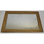 A 19th century carved giltwood and gesso framed wall mirror, 4'7" x 2'11".