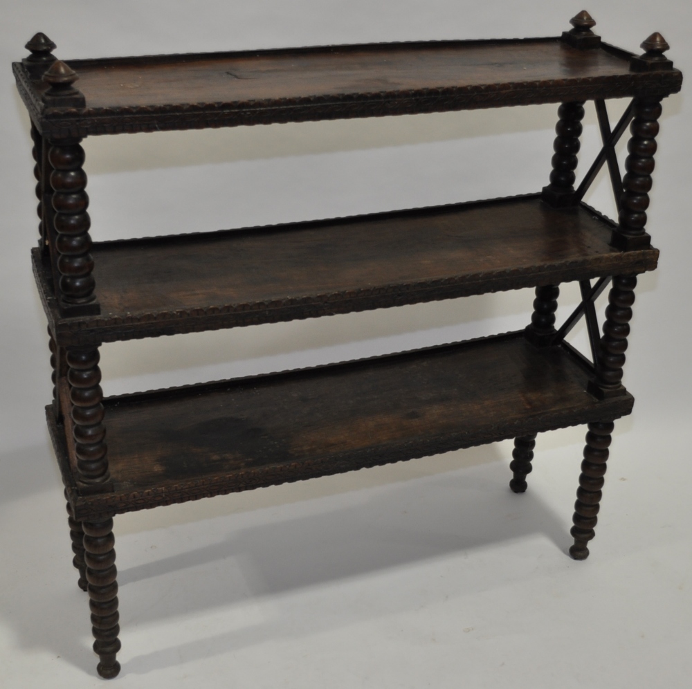 An Antique rosewood 3-tier stand, with carved edge, cross pierce sides and bobbin turned supports,
