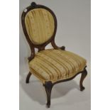 A Victorian carved walnut nursing chair on cabriole legs.