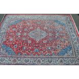 A large cream and red ground Sarouq carpet with allover symmetrical pattern and borders,