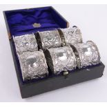 Cased set of 6 silver napkin rings, with cherub classical decorated surrounds, Birmingham 1896.