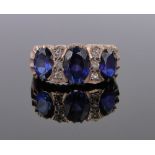 A large unmarked gold sapphire and white stone set ring, size O.