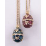 2 continental red and green enamel decorated egg shaped pendants on chains.