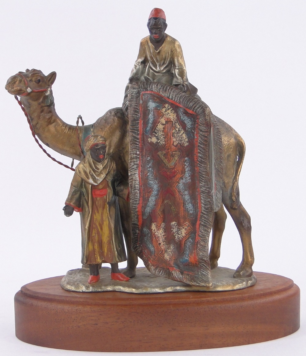 An Austrian painted spelter table lighter in the form of Arab carpet sellers and camel,