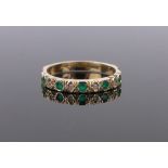 An 18ct gold emerald and diamond set half eternity ring, size N.