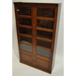 A 1920s oak Minty style bookcase, having 2-sectional glazed panelled doors with cupboards under,