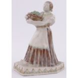 A glazed Studio Pottery figure of a woman carrying a basket of fruit,