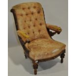 A Victorian carved walnut framed open armchair on turned legs with button back upholstery.
