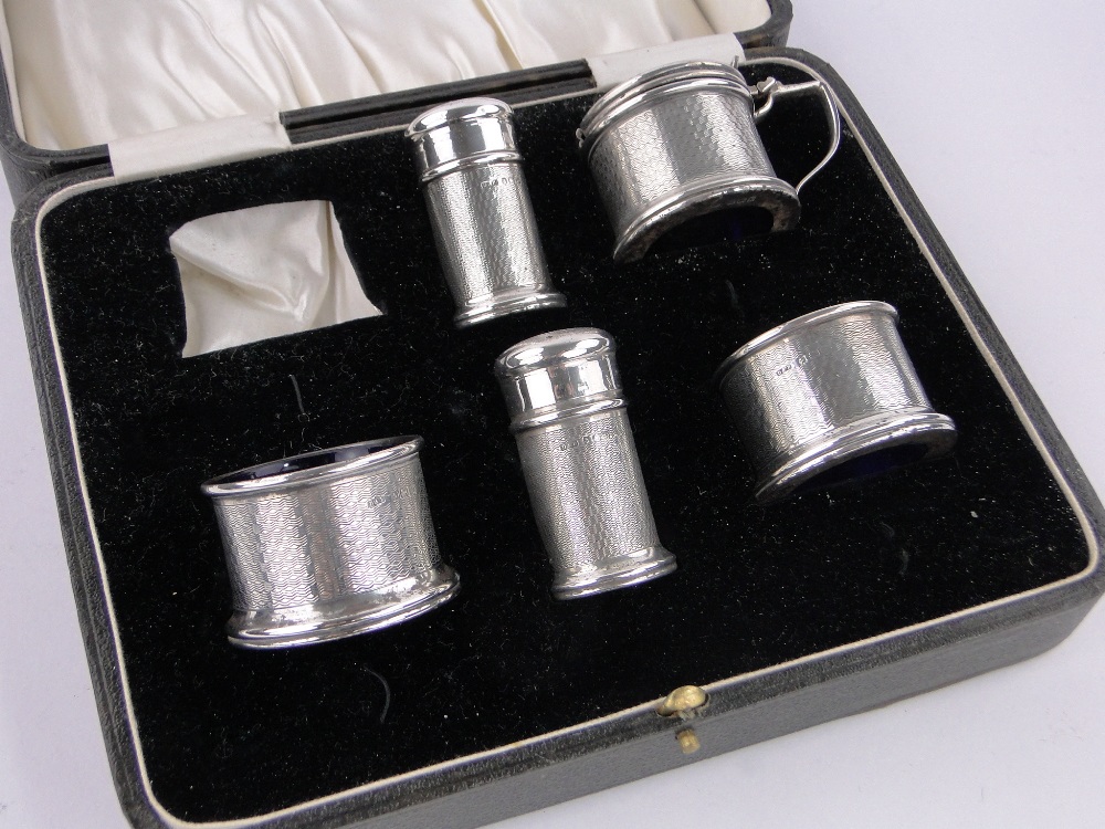 A 5-piece engine turned silver cruet set, with blue glass liners, Birmingham 1928.