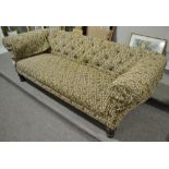 An Edwardian button back upholstered Chesterfield settee, raised on turned legs, length 7',