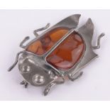 A large amber and unmarked silver bug brooch, length 10cm.