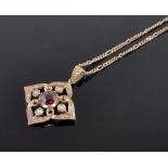 A 15ct gold garnet and pearl set open work pendant on chain.