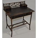 An Oriental design bamboo and black lacquered writing table, with raised back and drawer fitted top,